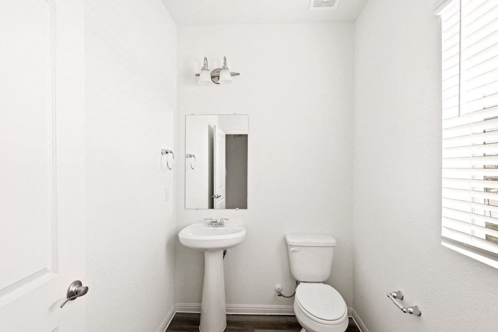 a bathroom with a toilet sink and mirror