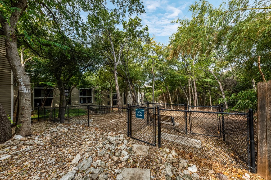 Large woodsy dog park at Hillside Creek Apartments in Austin, TX