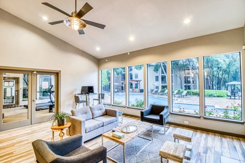 Leasing office lounge area a couch and chairs and view to the pool at Hillside Creek Apartments in Austin, TX