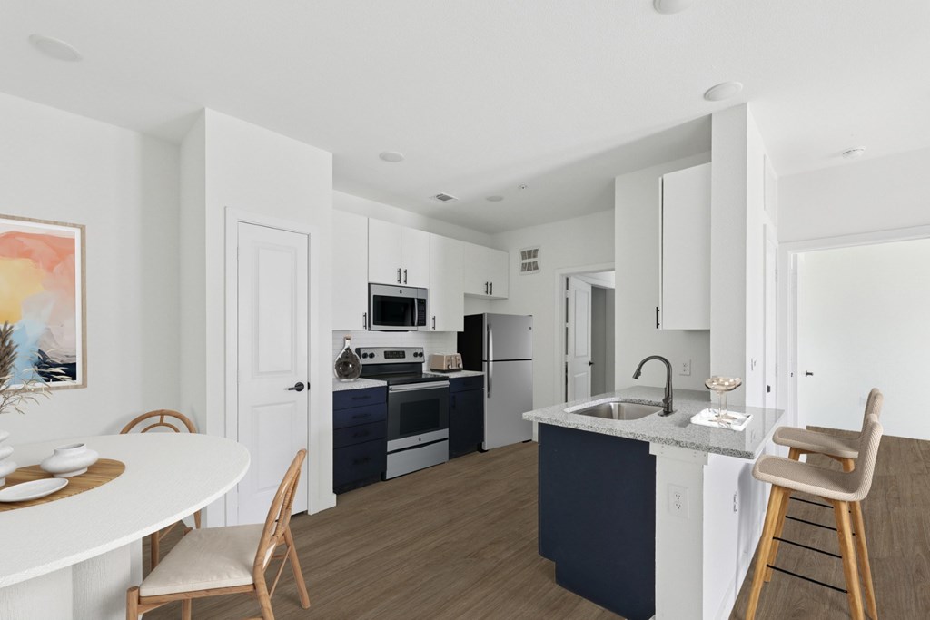 A kitchen with a white table and chairs and a blue island.