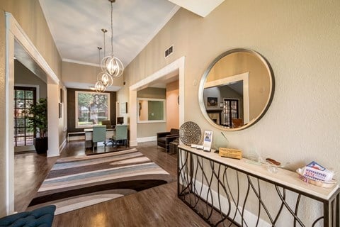 a resident clubhouse with a large mirror and a table with chairs in the background