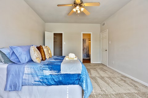 A1 bedroom with a bed, closet, and a ceiling fan at The Inverness Apartments in Houston, TX