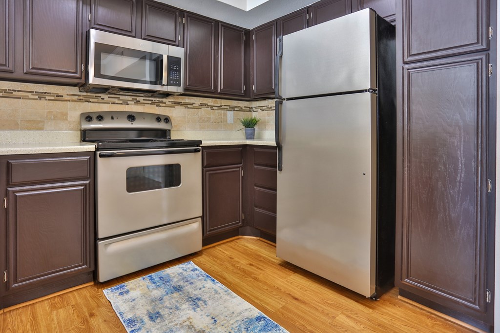 A1 kitchen with wood cabinets and stainless steel appliances at The Inverness Apartments in Houston, TX