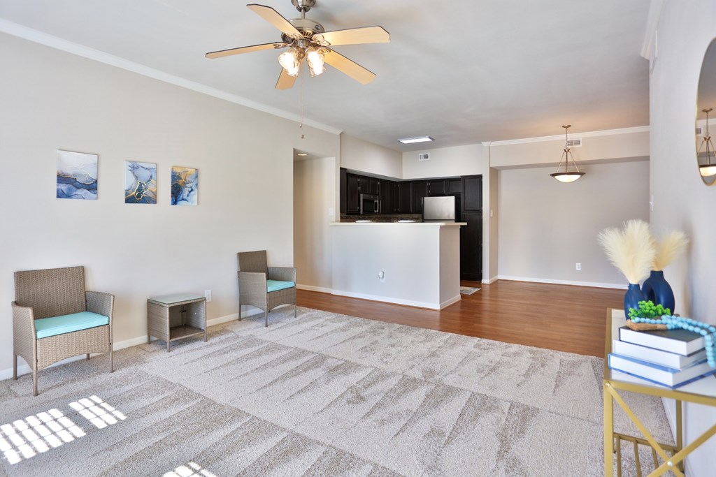 A1 living room with a ceiling fan and a grey carpet at The Inverness Apartments in Houston, TX