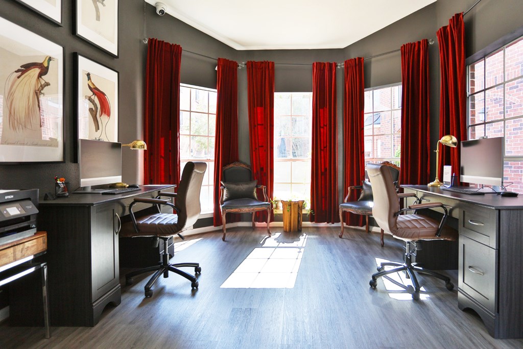 A business center with computers and red curtains at The Inverness Apartments in Houston, TX