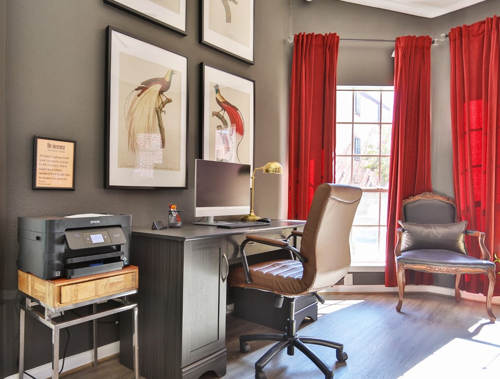 A business center with a desk, chair, and printer at The Inverness Apartments in Houston, TX