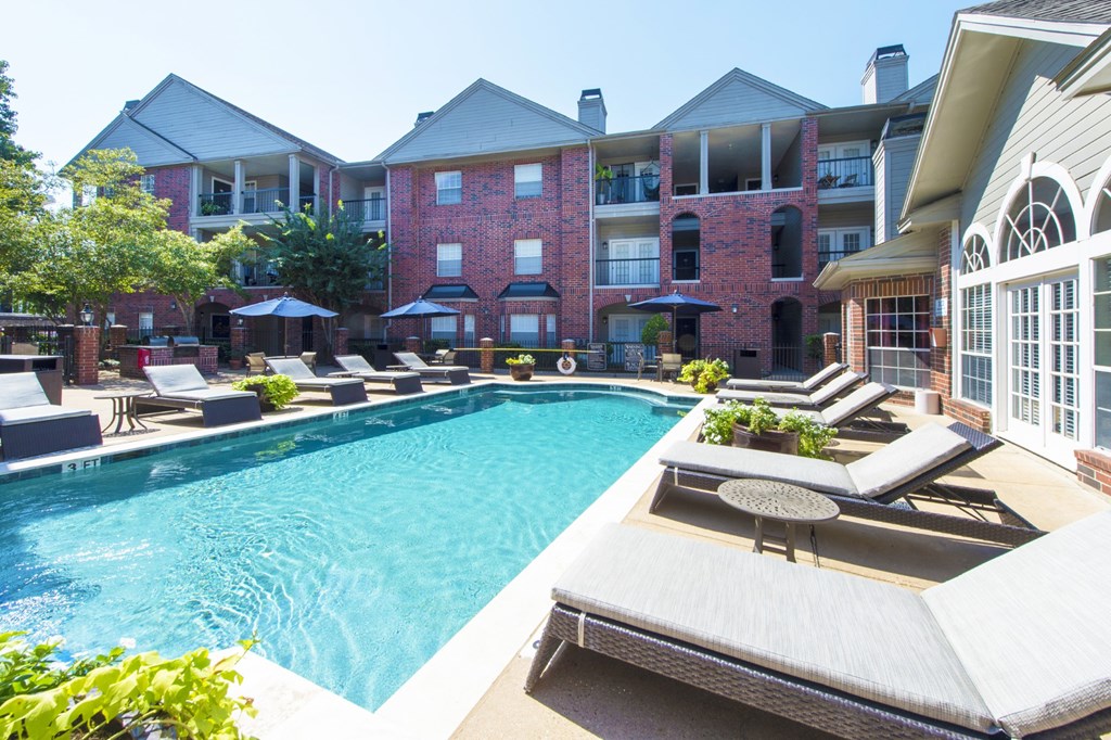 A swimming pool with an apartment building in the background at The Inverness Apartments in Houston, TX