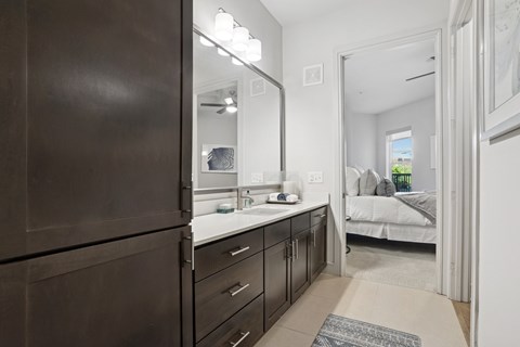 A bathroom with a large mirror and ample cabinet space at Knox Heights in Dallas, TX