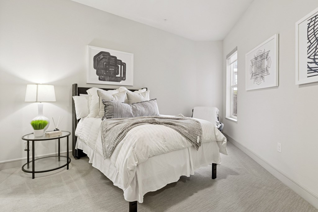 A bedroom with a bed, nightstand, and wall art pieces at Knox Heights Apartments in Dallas, TX