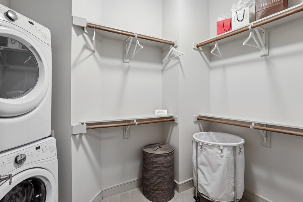 Walk in closet with a washer and dryer, a waste basket, and shelves at Knox Heights in Dallas, TX