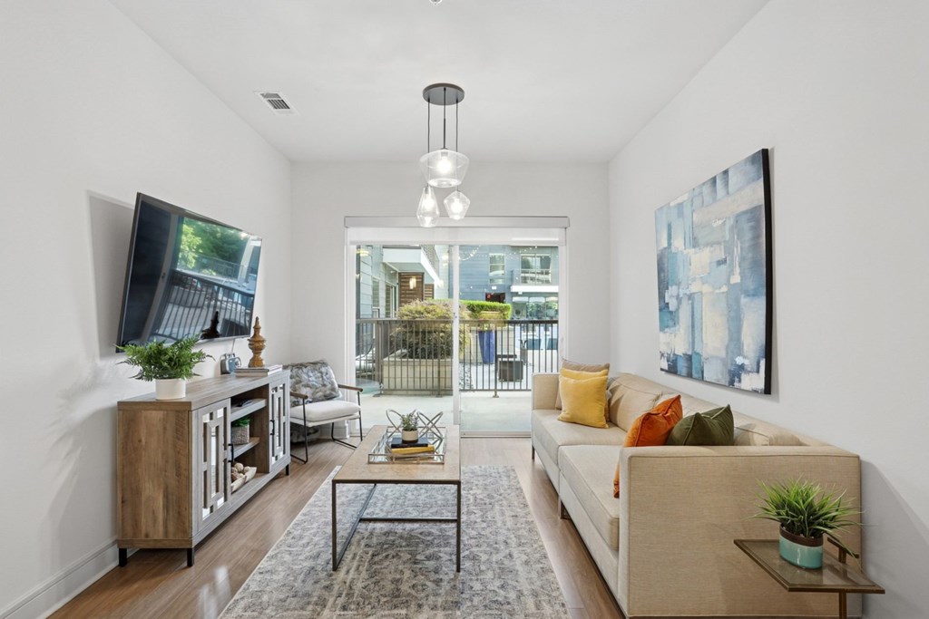 A living and dining room with a couch, and a television at Knox Heights Apartments in Dallas, TX