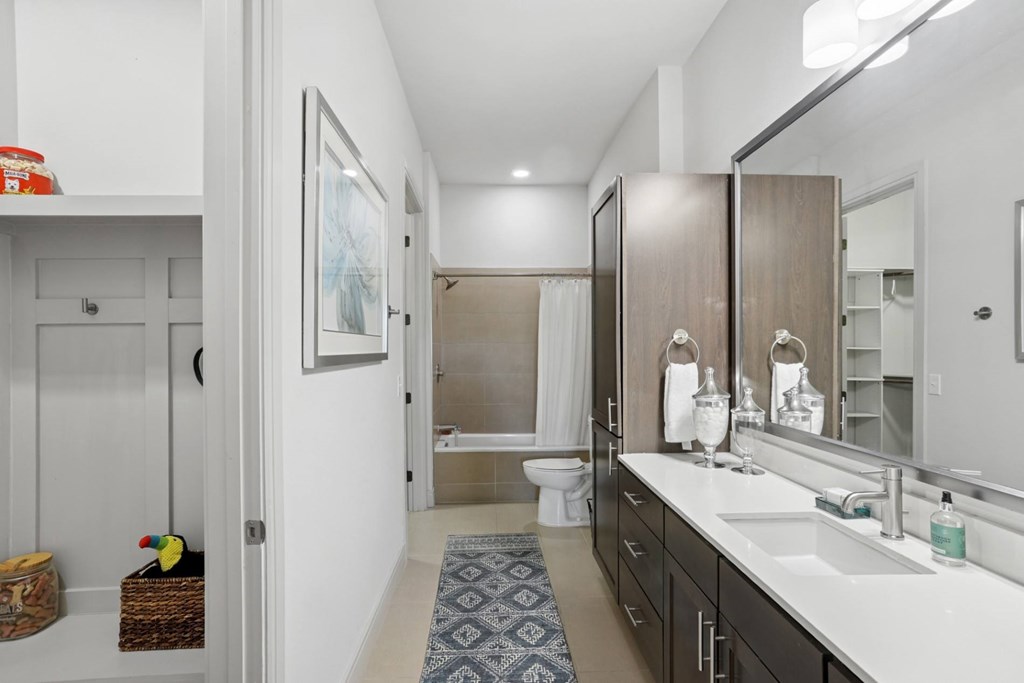 A bathroom with a toilet, sink, and mirror at Knox Heights Apartments in Dallas,  TX