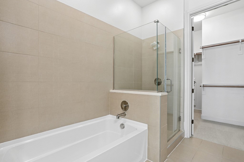 A bathroom with a white bathtub and a glass enclosed shower at Knox Heights Apartments in Dallas, TX