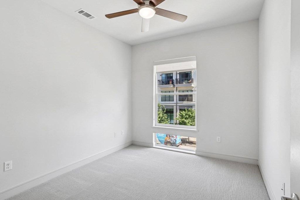 A bedroom with a window and a ceiling fan at Knox Heights Apartments in Dallas, TX