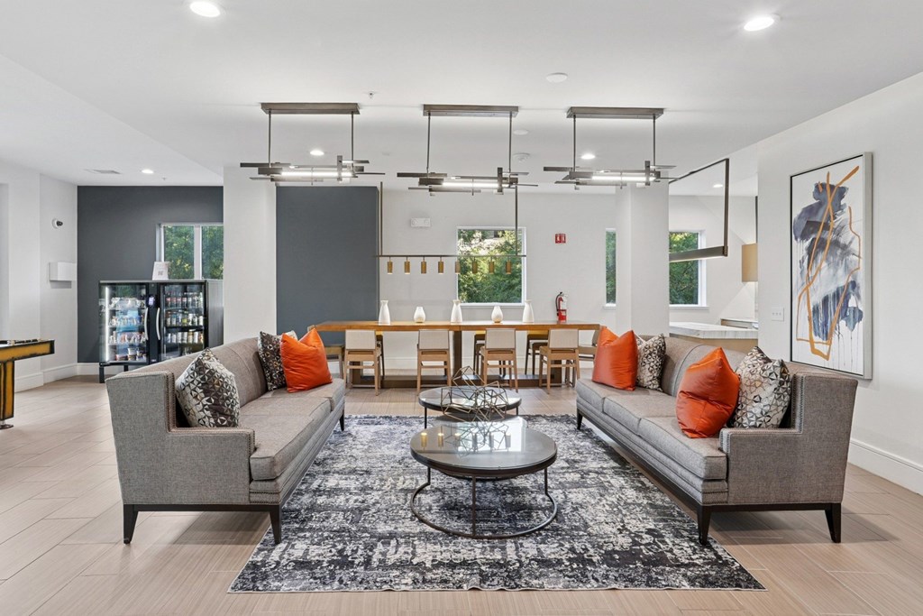 An entertainment lounge with grey sofas, a coffee table, and a gray rug at Knox Heights Apartments in Dallas, TX