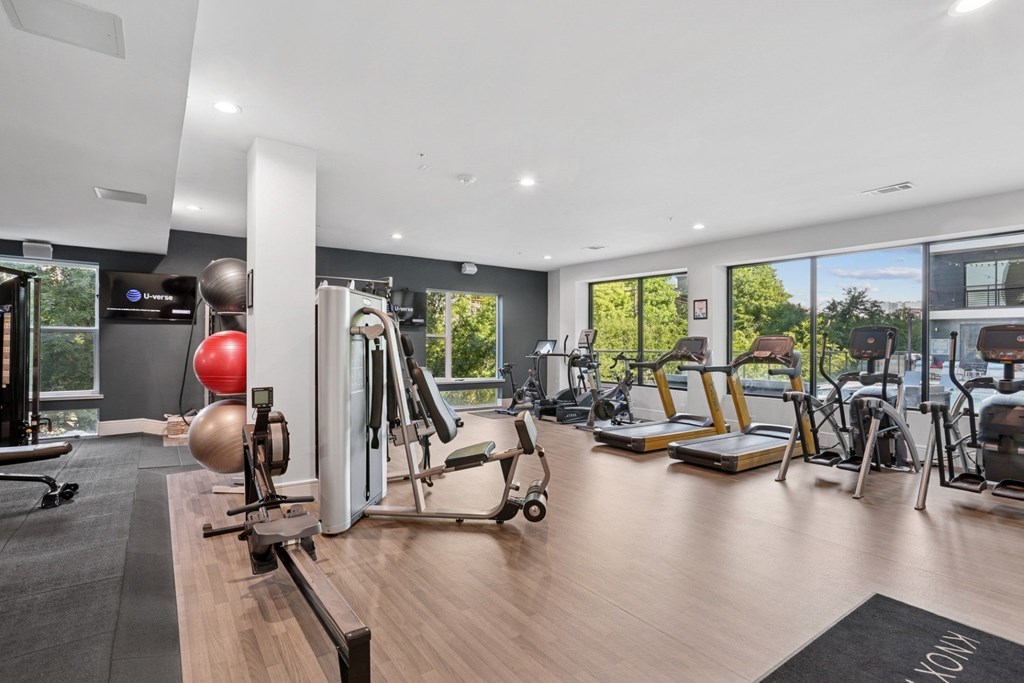 A gym with a variety of equipment including treadmills, weights, and a rowing machine at Knox Heights Apartments in Dallas, TX