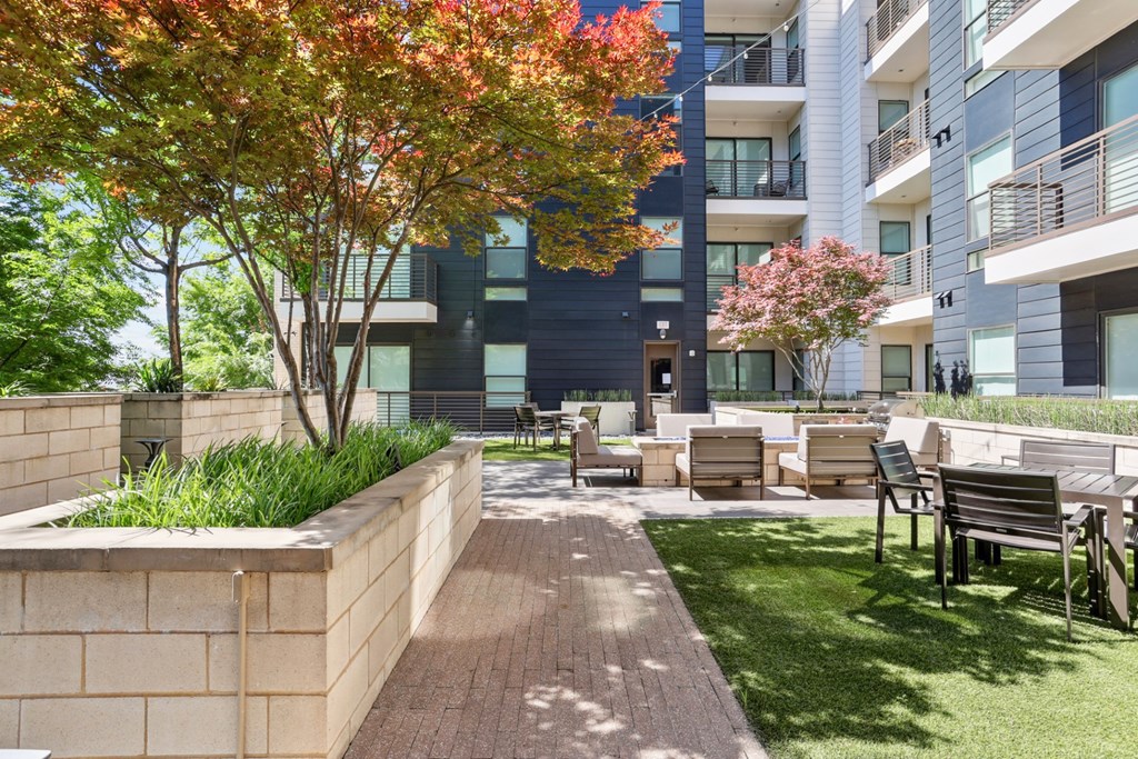 A modern apartment complex with a landscaped outdoor courtyard at Knox Heights Apartments in Dallas, TX
