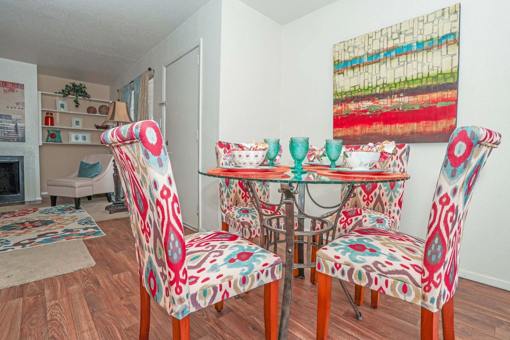 A dining room with a table and colorful chairs at Laurel Parc apartments in Shreveport, LA.