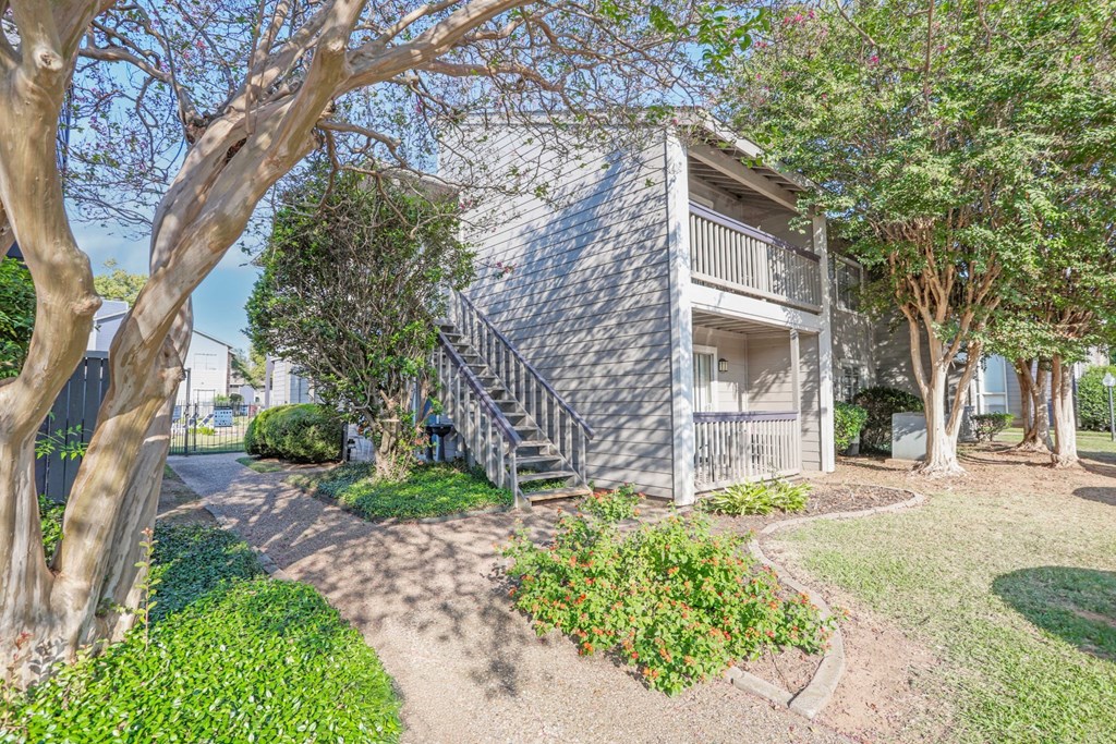 Two-story apartment building with beautiful landscaping surrounding it at Laurel Parc apartments in Shreveport, LA.