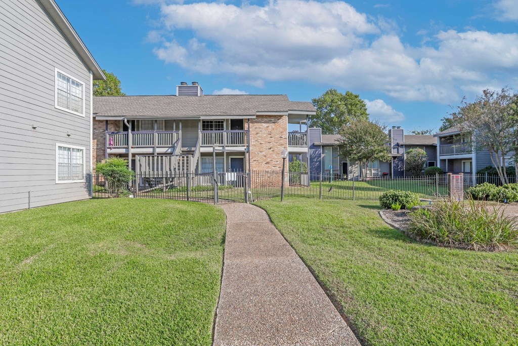 Walkway toward our beautiful apartments on a sunny day with a clear sky at Laurel Parc apartments in Shreveport, LA.