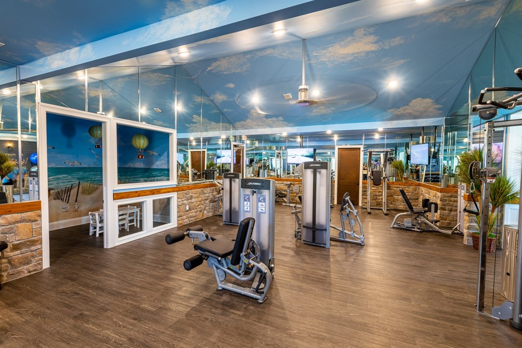 a home gym with a ceiling mural of the sky