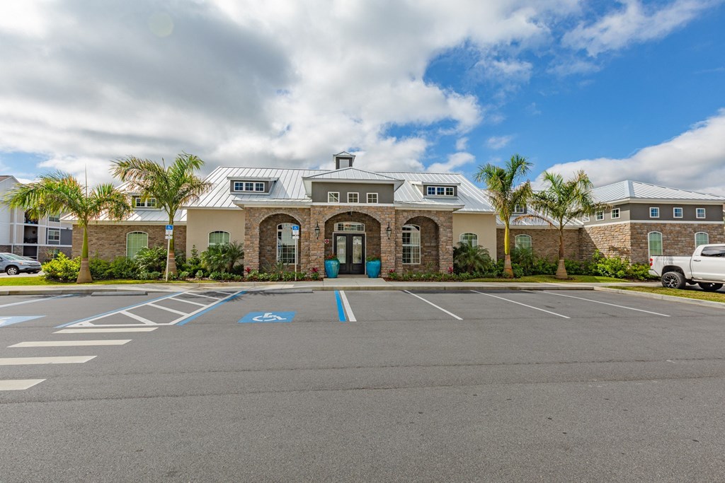 an empty parking lot in front of a building with palm trees
