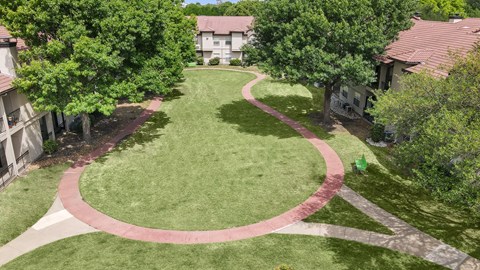 an aerial view of a grassy area with a circular walkway