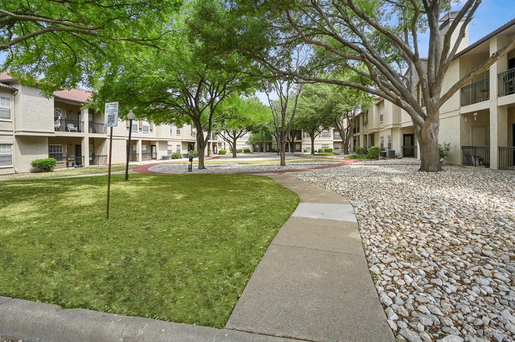 a view of the courtyard at the whispering winds apartments in pearland, tx