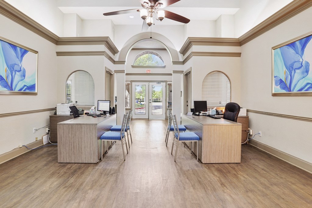 an office with two desks and a ceiling fan