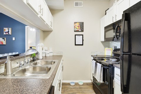 a kitchen with white cabinetry and black appliances