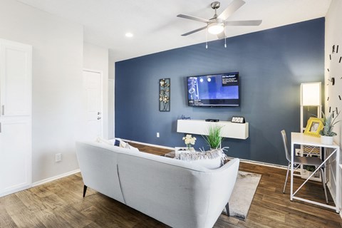 a living room with a blue accent wall and a white couch
