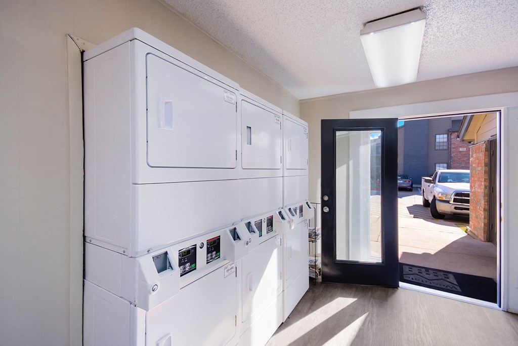 a kitchen with white cabinets and a door to a street