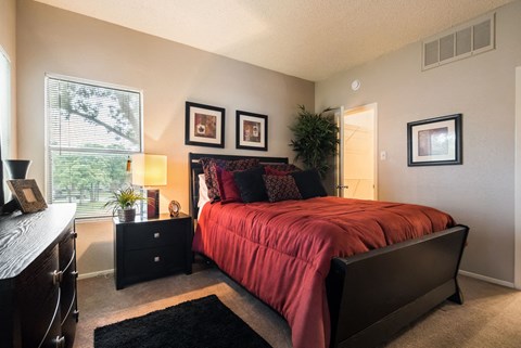 a bedroom with a bed and a dresser and a window