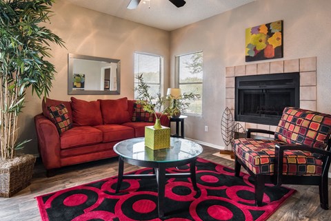 a living room with a red rug and a fireplace