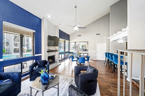 a living room with blue chairs and a fireplace
