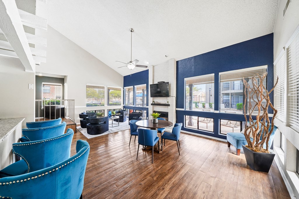 a living room with blue chairs and a table and a large window