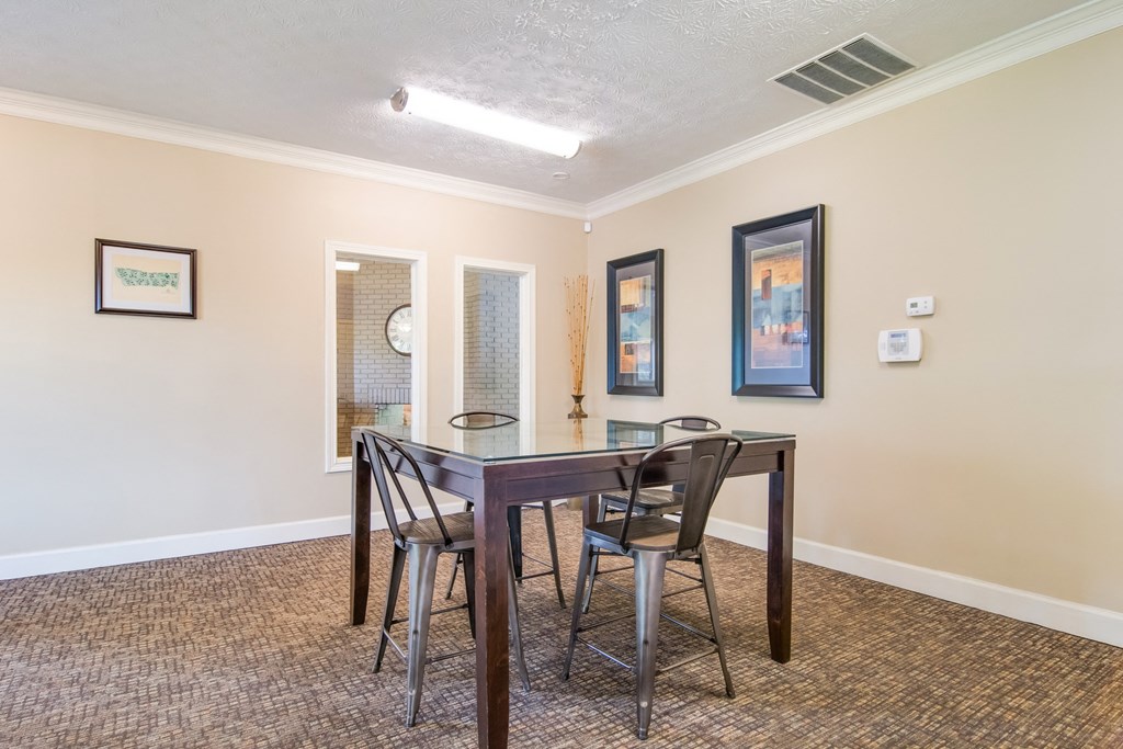 a dining area with a table and chairs and a window