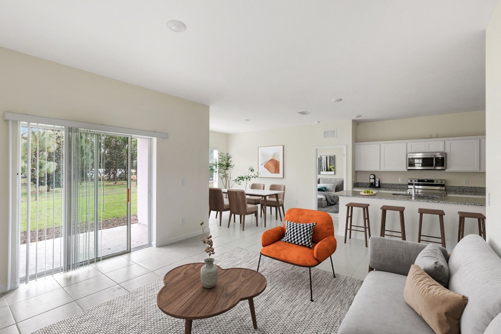 a living room and kitchen with a sliding glass door