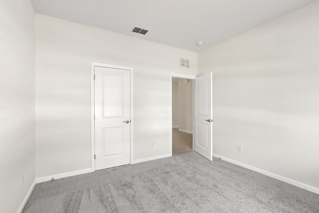 a bedroom with white walls and carpet