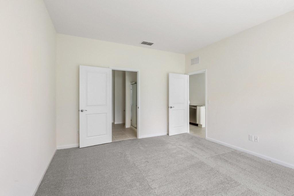 a bedroom with white walls and carpet