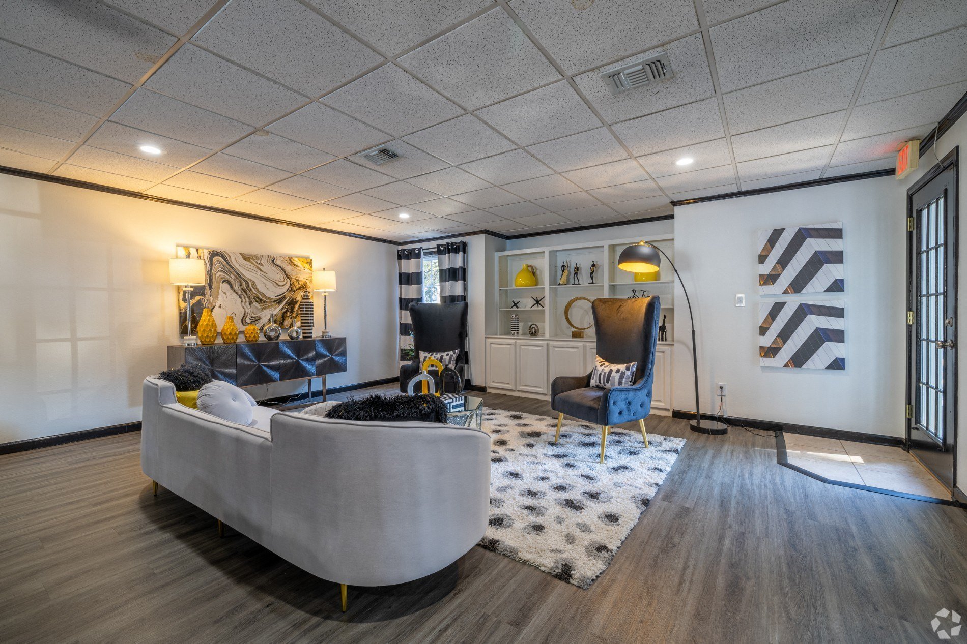 A modern living room with a grey sofa and a patterned rug.