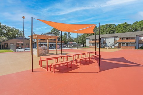 Picnic benches and a communal barbeque in a paved area at The Marq in Shreveport, LA