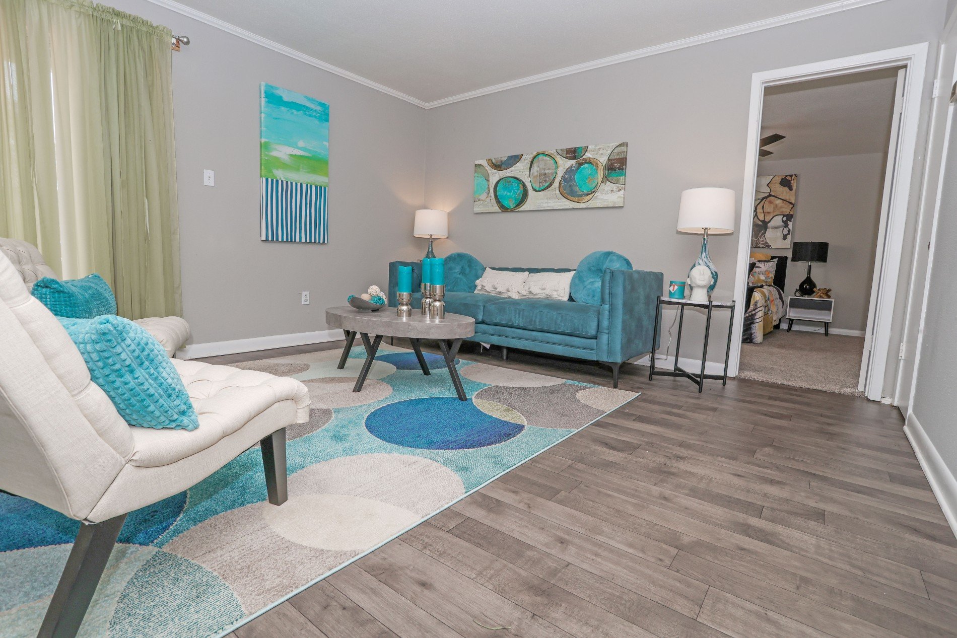 A living room with a white chair and a blue couch.