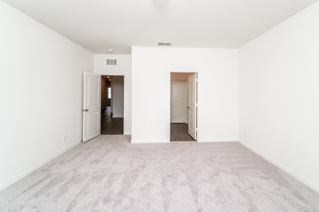 a bedroom with white walls and carpet
