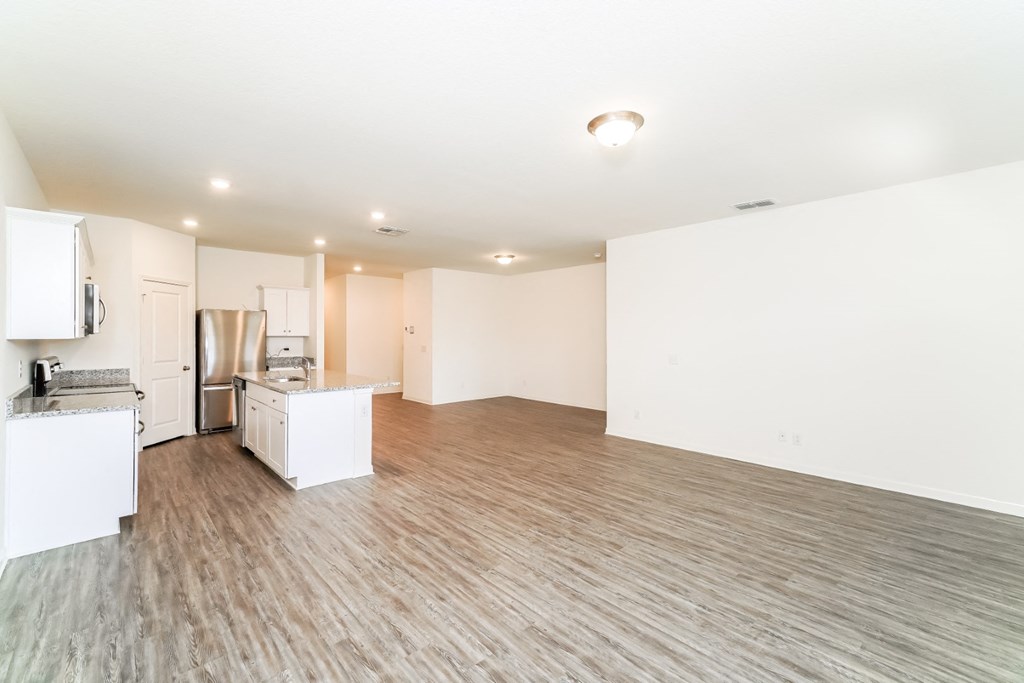 a kitchen and living room in a 555 waverly unit at Beacon at Meridian, San Antonio