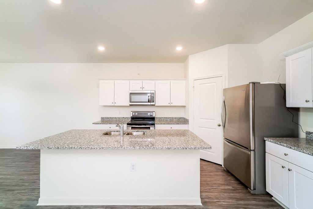 a kitchen with white cabinets and a granite counter top at Beacon at Meridian, San Antonio, 78245