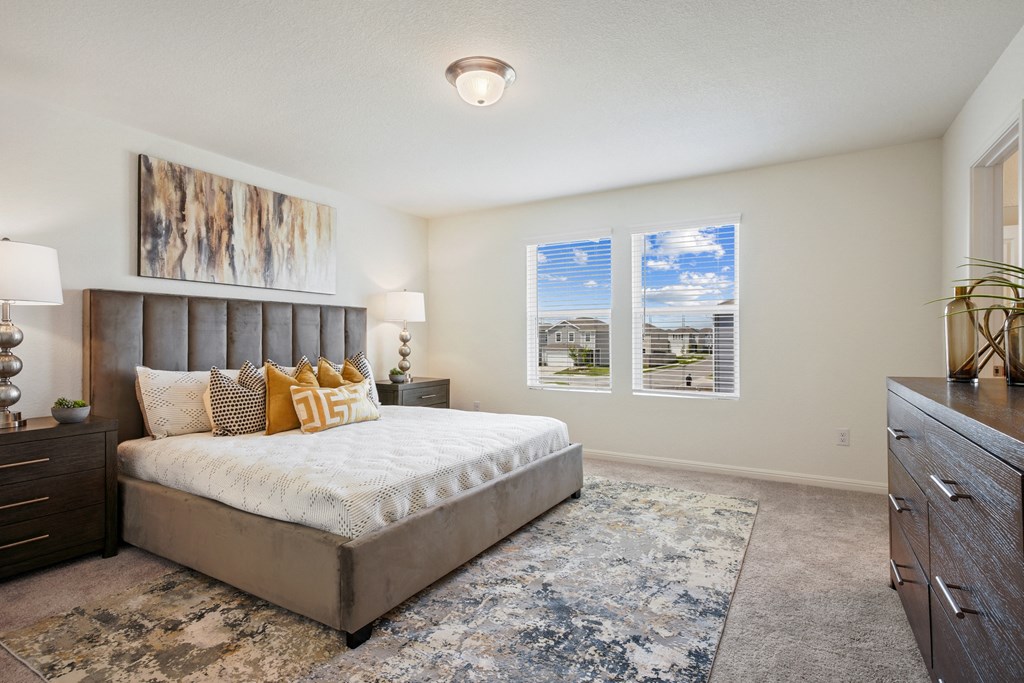 a bedroom with a bed and two windows