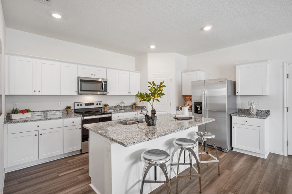 Maple open kitchen with island, granite counter tops, and stainless steel appliances at Beacon at Ashley River Landing in Summerville, SC