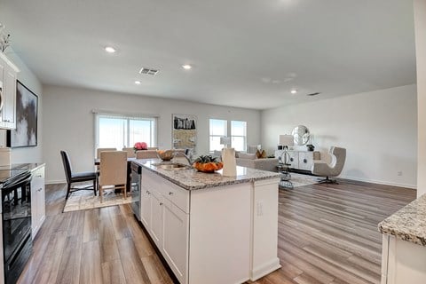 a kitchen and living room with hardwood floors and white walls at Beacon at Meridian, Texas