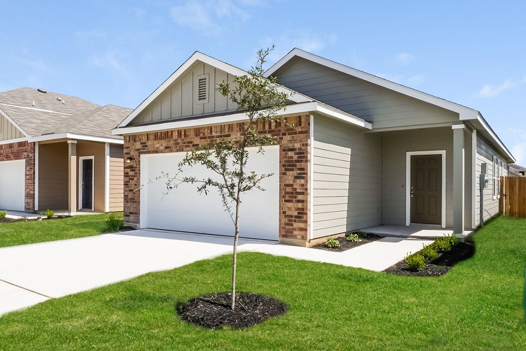 a home with a tree in the front yard at Beacon at Meridian, San Antonio, TX